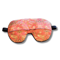 Weighted eye mask with a red bird design on a transparent background