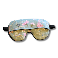 Weighted eye mask with a green floral design on a transparent background