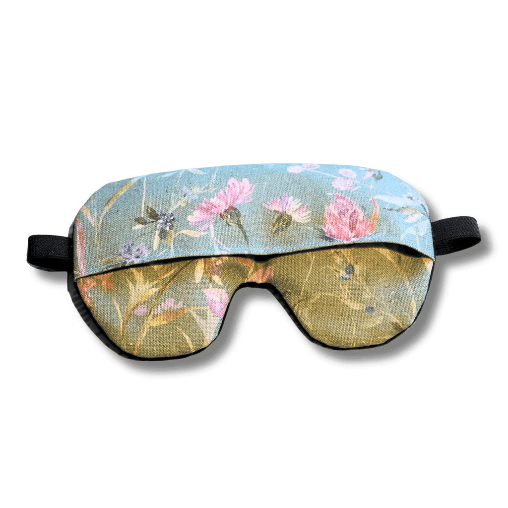 Weighted eye mask with a green floral design on a transparent background