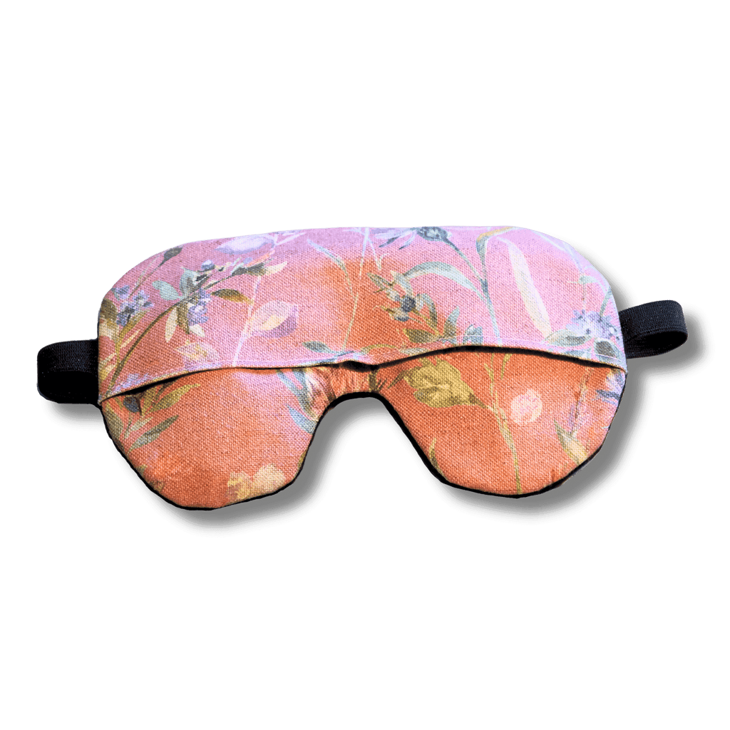Weighted eye mask with a pink floral design on a transparent background