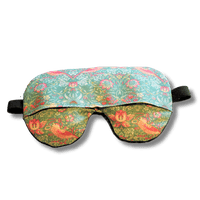 Weighted eye mask with a green bird design on a transparent background