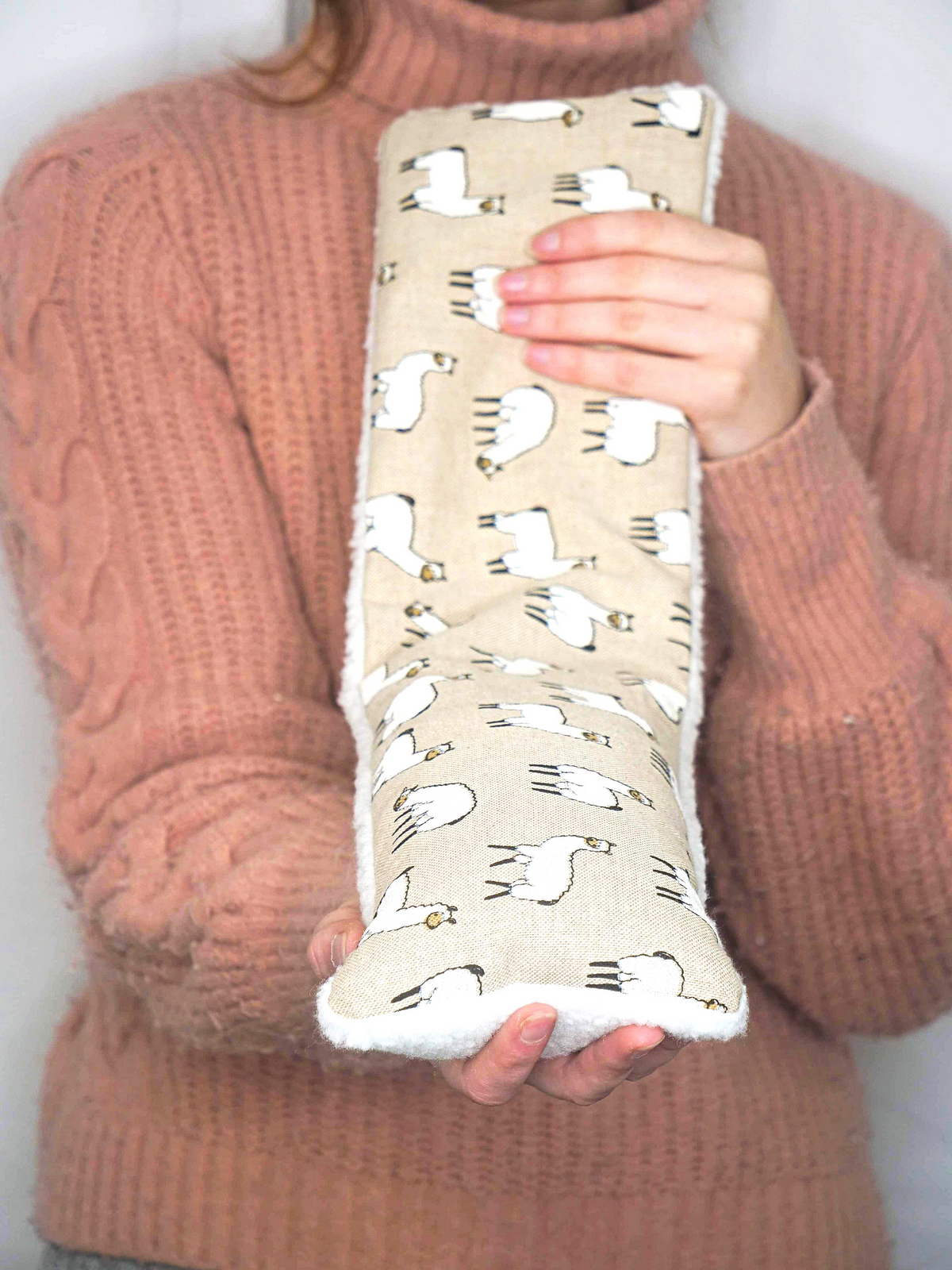 Girl holding wheat bag with llama design